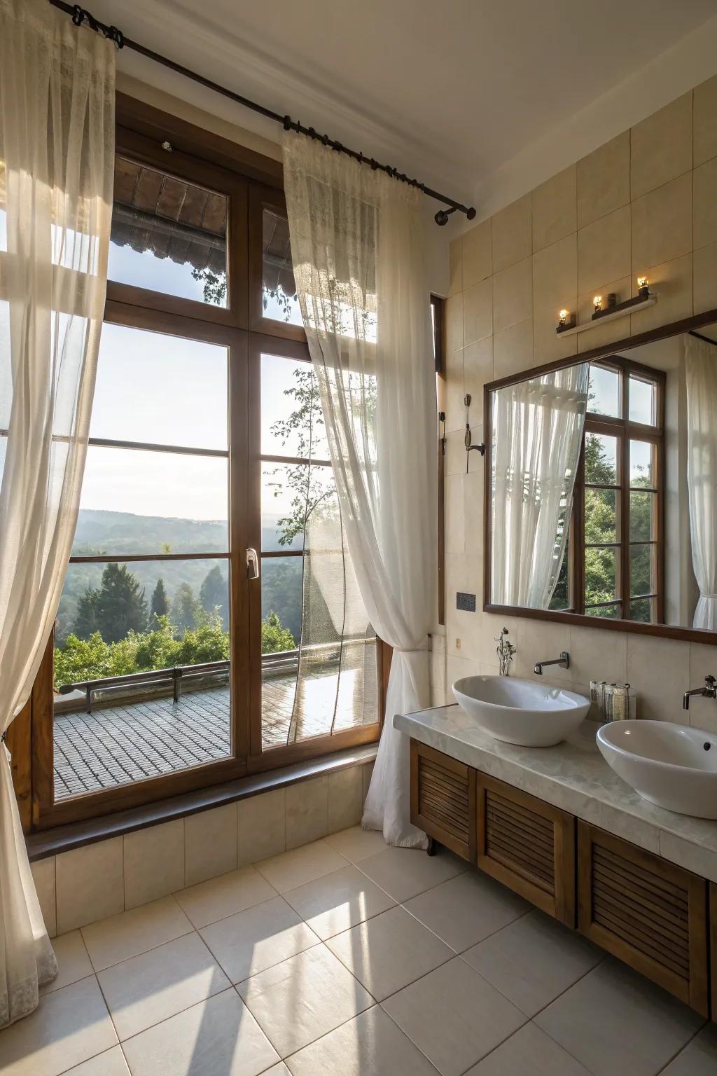 A bathroom flooded with natural light through large windows and sheer curtains.