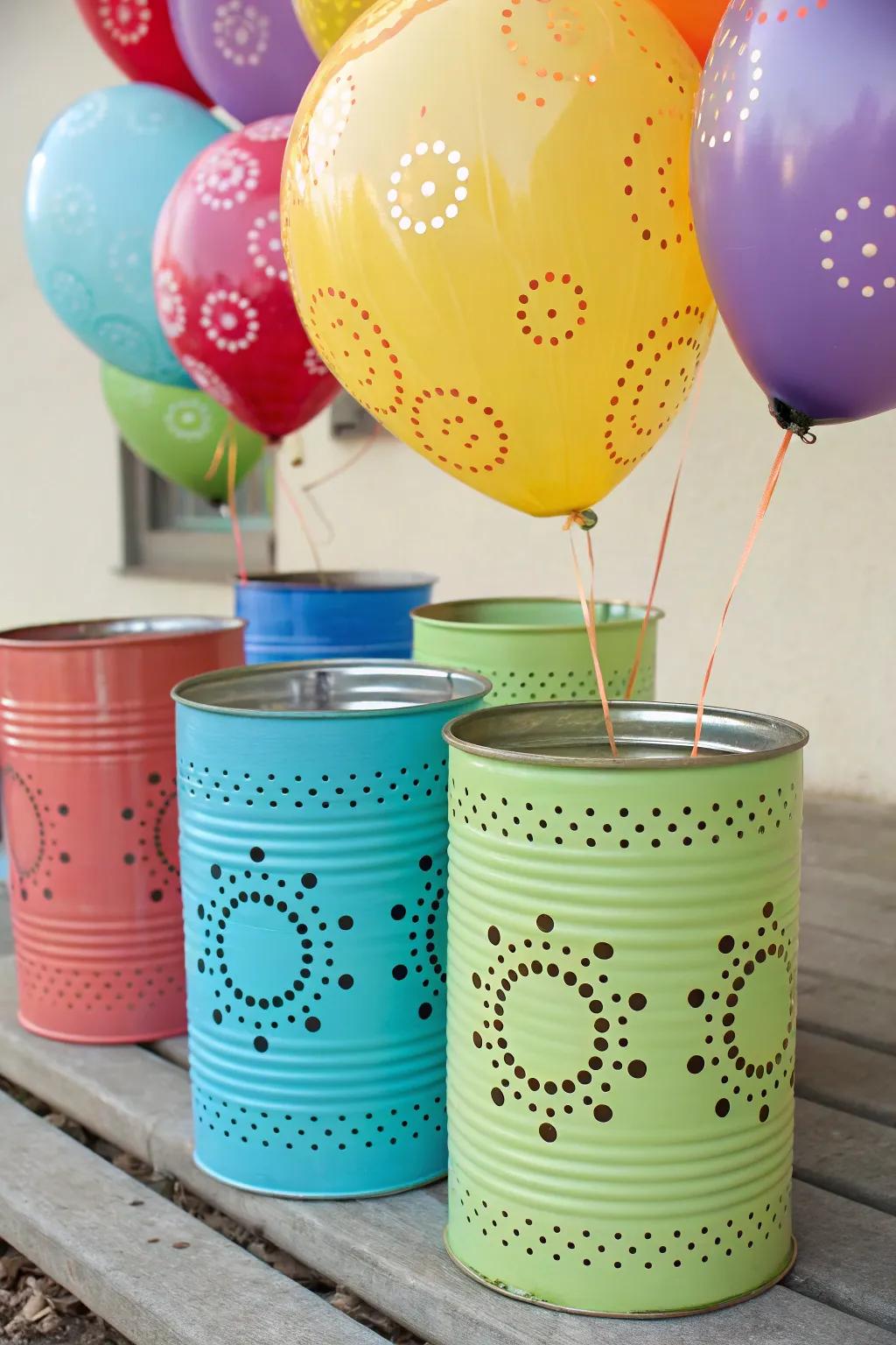 Whimsical tin cans painted in vibrant colors, used as playful balloon weights.