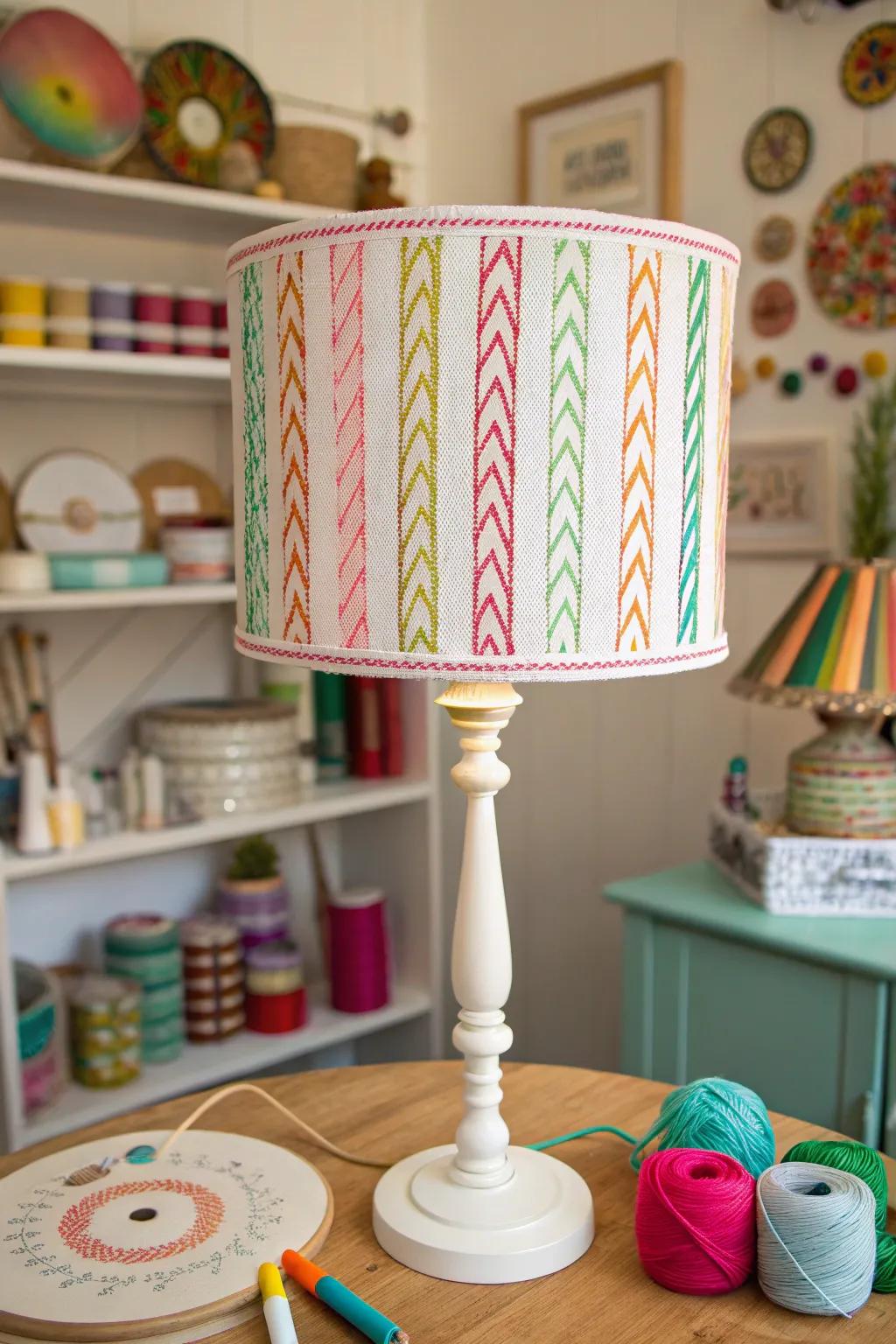 A craft room lamp shade with colorful embroidery floss stripes.