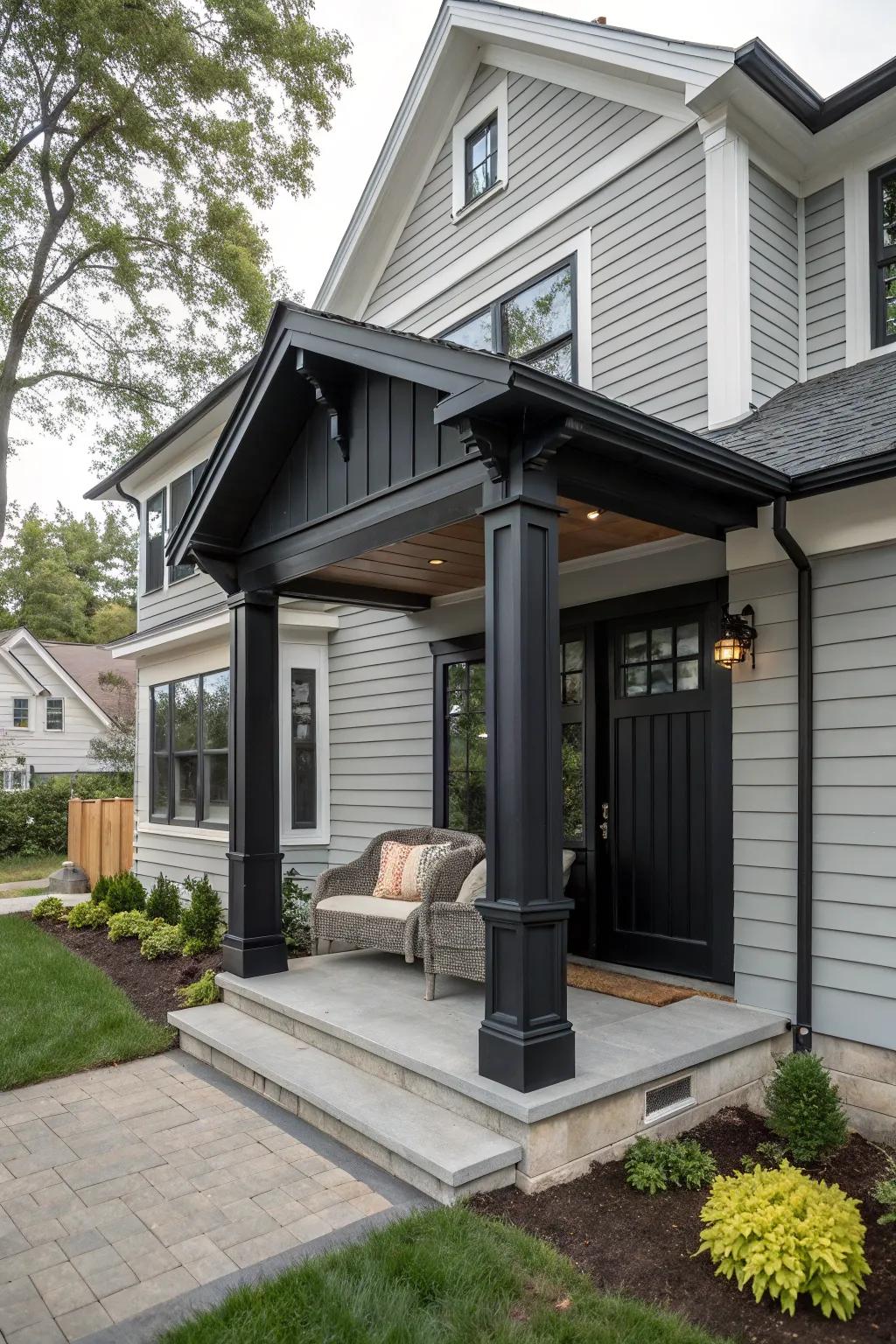 A house with a grey exterior and black detailed entryway, featuring an inviting porch.