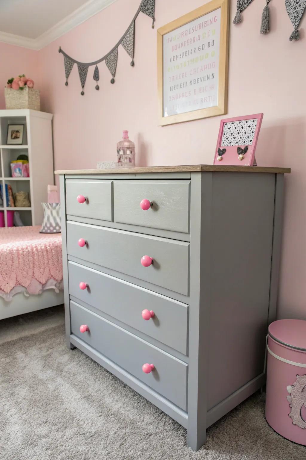 A grey dresser with pink details adds a touch of whimsy and style.