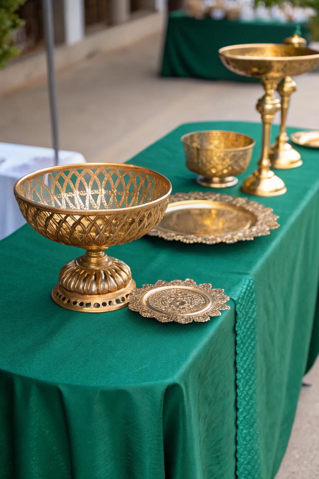 Gold decorative bowls accenting a table with an emerald green tablecloth.