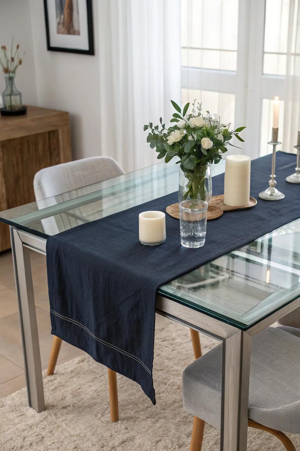 A navy table runner enhancing a glass dining table.