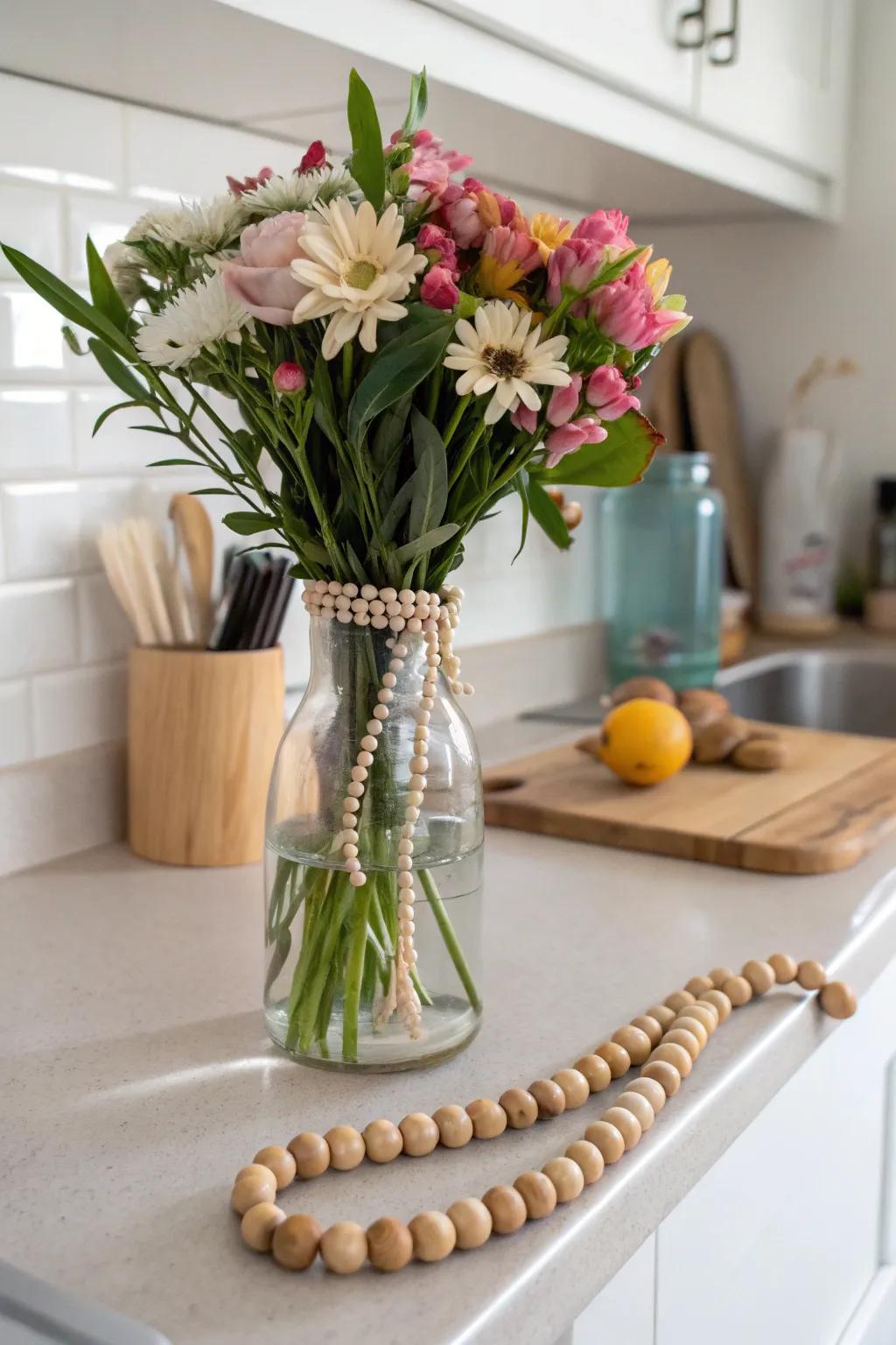 A vase wrapped with wooden beads adding charm to a floral arrangement.