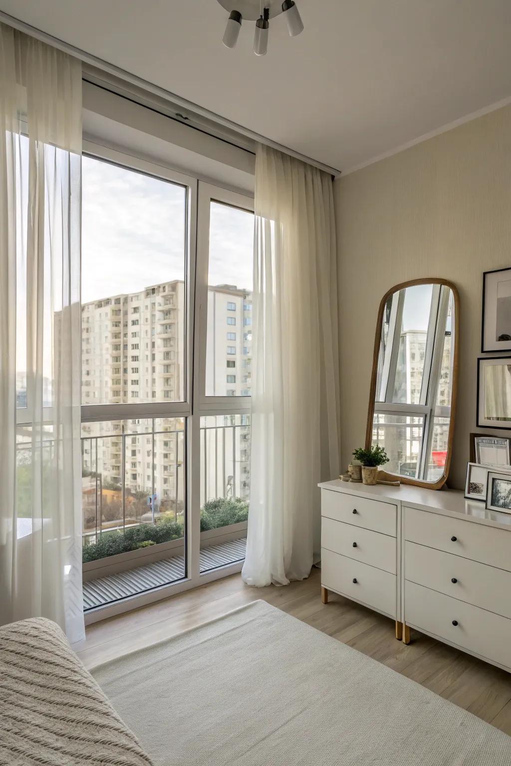 Sheer curtains and mirrors enhance natural light in a small apartment.