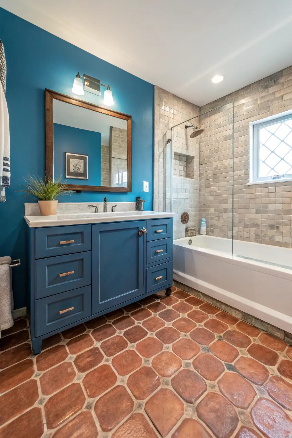 A bathroom with Saltillo tile flooring and a striking blue accent wall.