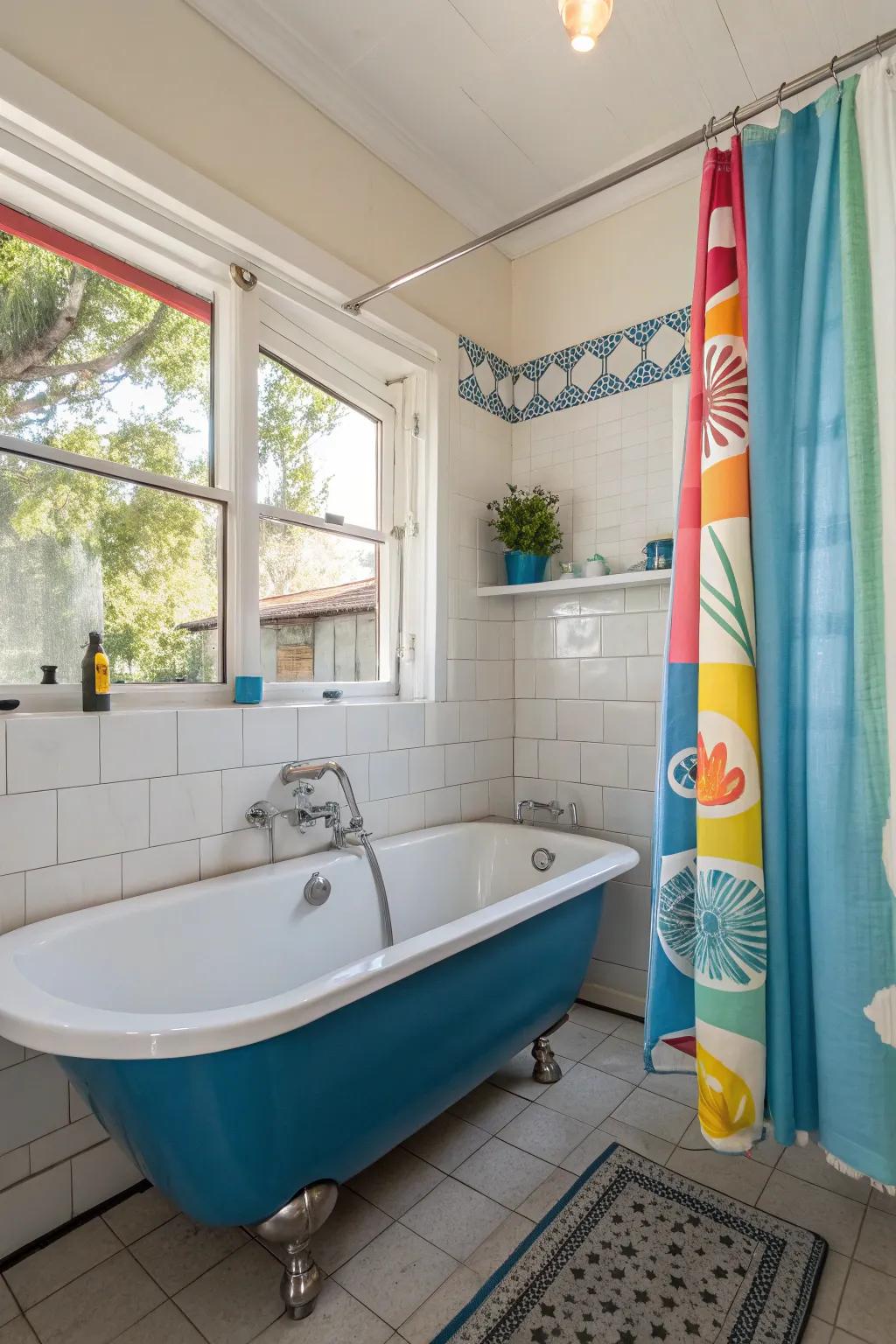 An artistic shower curtain complements the blue bathtub while adding visual interest.