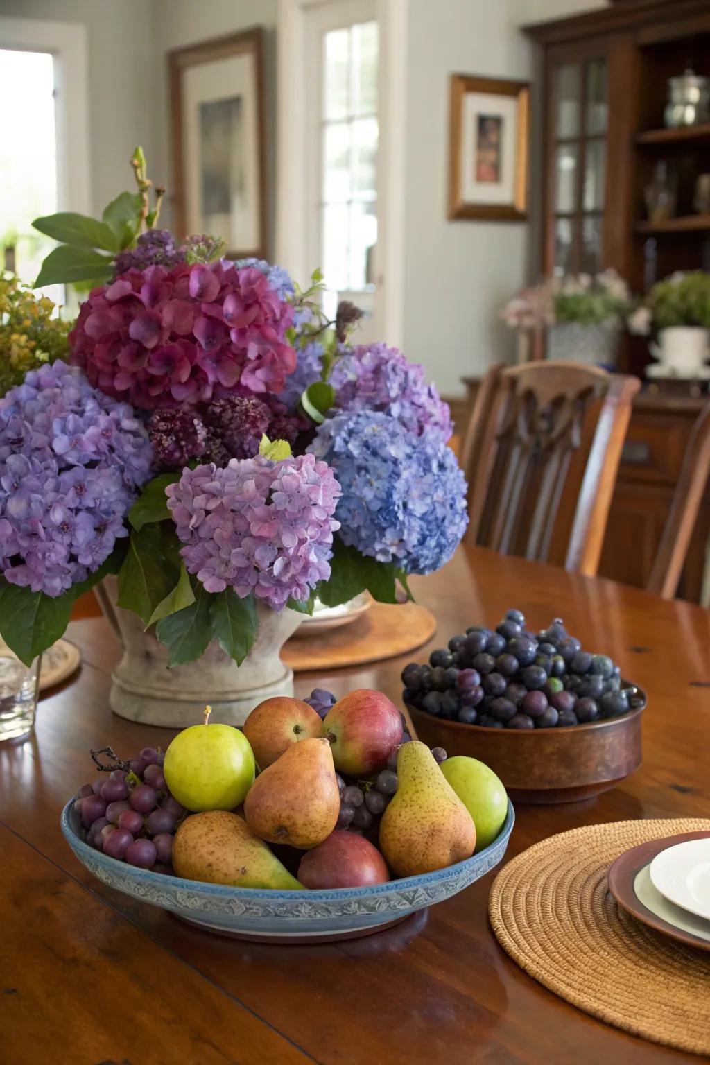 Hydrangeas and fruits create a bountiful centerpiece.