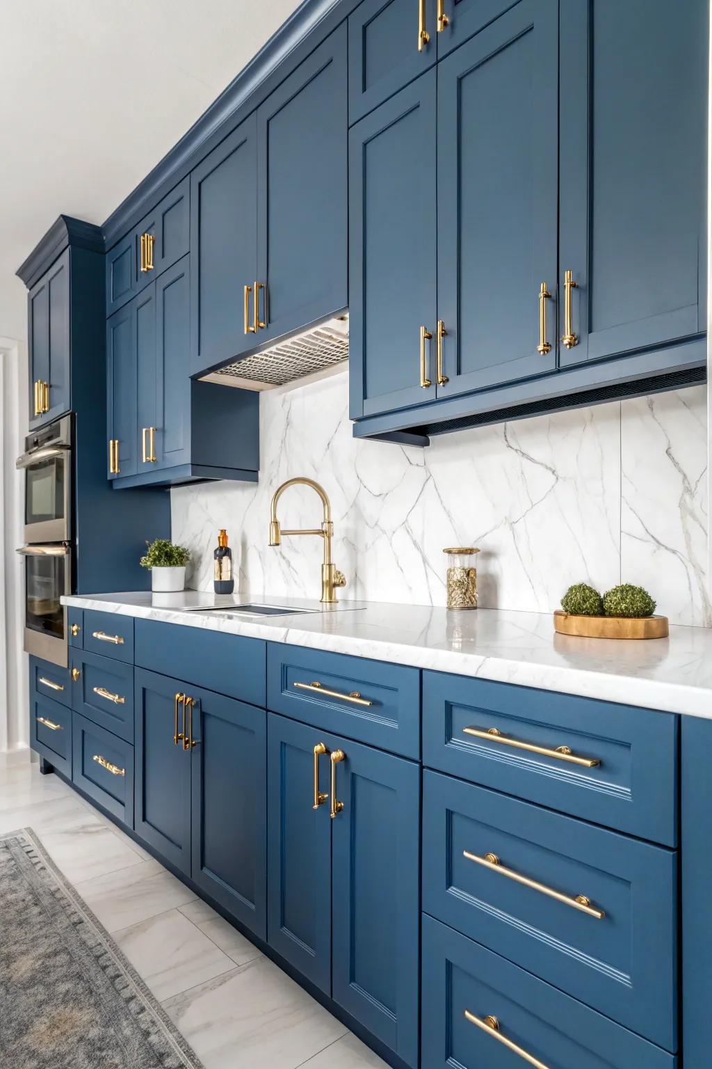 Blue cabinets with gold hardware and white marble countertops create a striking visual contrast.